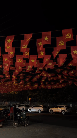 Red flags with yellow symbols displayed across Nam Nha Trang Ward