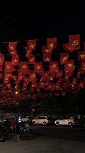 Red flags with yellow symbols displayed across Nam Nha Trang Ward