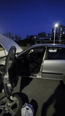 Silver sedan with hood open on a Varna street at dusk