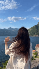 Person gazes across water in Montenegro coastal town