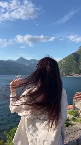 Person gazes across water in Montenegro coastal town
