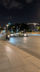 Nighttime urban scenes capture motorcycle traffic, illuminated waterfront bridge