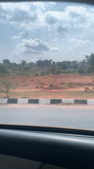Vehicle passenger captures cloudy afternoon scenery in Gwarinpa, Nigeria