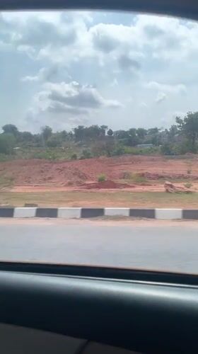 Vehicle passenger captures cloudy afternoon scenery in Gwarinpa, Nigeria