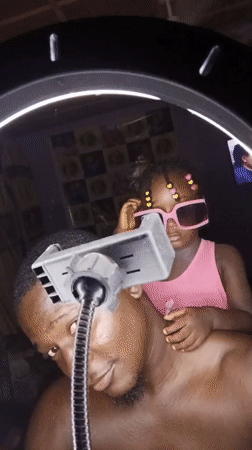 Goofing around with pink sunglasses on a bed in Akwanga