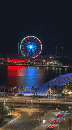 Illuminated Ferris wheel draws crowds in bustling Lusail nighttime