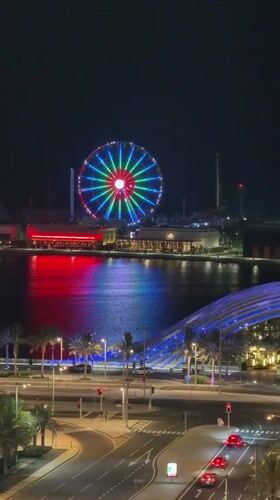 Illuminated Ferris wheel draws crowds in bustling Lusail nighttime