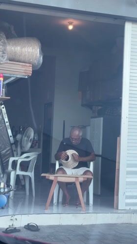 Man crafting woven object in Kutuh building