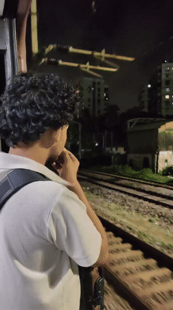 Night train ride through Mumbai, door open to the dark.
