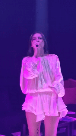 Woman performs on stage in purple lighting, Thailand