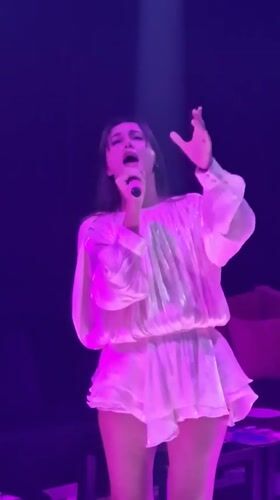 Woman performs on stage in purple lighting, Thailand
