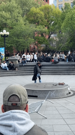 Cape-wearing performer entertains small crowd in NYC public space