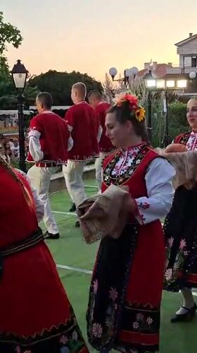 Bulgarian folk dancers perform outdoors at a late-summer festival