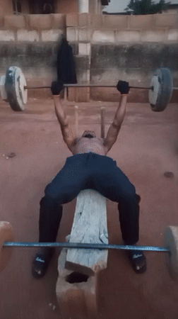 Man uses improvised gym equipment for outdoor workout in Bukuru