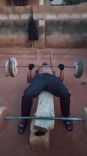 Man uses improvised gym equipment for outdoor workout in Bukuru