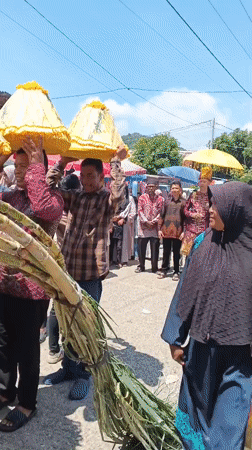 Traditional wedding procession with decorated conical objects and outdoor feast