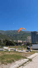 Paragliders soar over Montenegro coastal towns amid construction activity