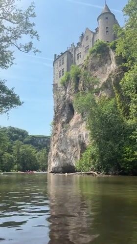 Kayakers paddle Lesse River below medieval Walzin Castle, Belgium