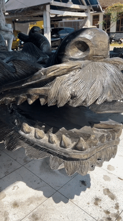 Tourist photographs wooden sculptures in Ubud District, Indonesia