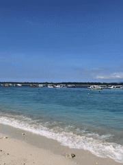 Tranquil Indonesian beach scene documented with boats offshore