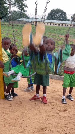 Children play on swings at Akwanga playground