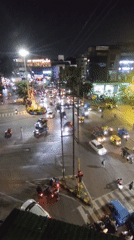 Nighttime traffic moves through a busy Indore intersection