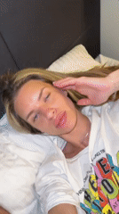 Person adjusts hair while lying on pillow in Berlin