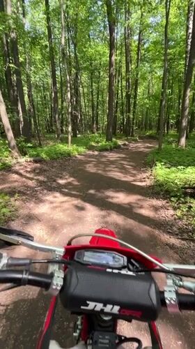 Dirt bike rider travels forest trail in Vasilyevo