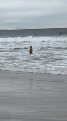 Cloudy afternoon on a Florianópolis beach, surfers and strollers