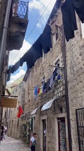 Tourist documents historic Kotor Old Town architecture and streetlife