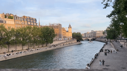 Parisians relax along Seine riverbanks as tour boat passes
