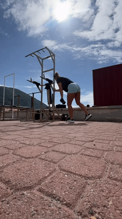 Woman exercises with dumbbells on Montenegro rooftop