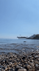 Tourist documents casual walk along Yalta embankment and beach