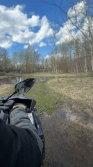 ATV rider navigates muddy forest terrain in Varskie, Russia