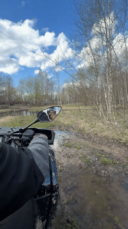 ATV rider navigates muddy forest terrain in Varskie, Russia