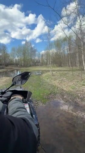 ATV rider navigates muddy forest terrain in Varskie, Russia