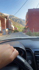 Driver navigates mountain village streets in Asgaour, Morocco