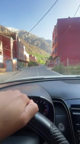 Driver navigates mountain village streets in Asgaour, Morocco