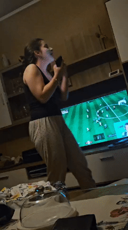 Woman dances at home while FIFA gaming streams captured