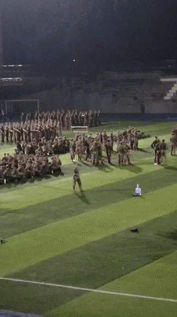 Military personnel gather on turf field in Shapingba District