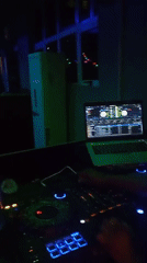 DJ performs evening set with colorful lighting at unknown venue