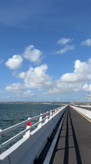 On and around a Bali sea bridge, with a coastal boat nearby