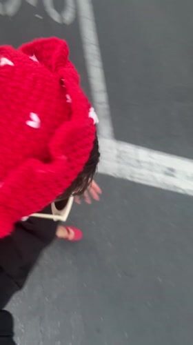 Person films self wearing strawberry hat in Los Angeles