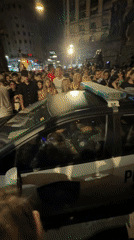 Crowd surrounds police car with flashing lights in Buenos Aires
