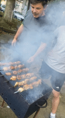 Backyard barbecue gathering in Tbilisi with grilled skewers and dogs