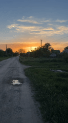 Rural sunset scene documented on dirt road in Leningradskaya