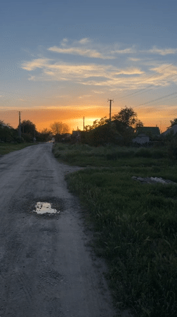 Rural sunset scene documented on dirt road in Leningradskaya