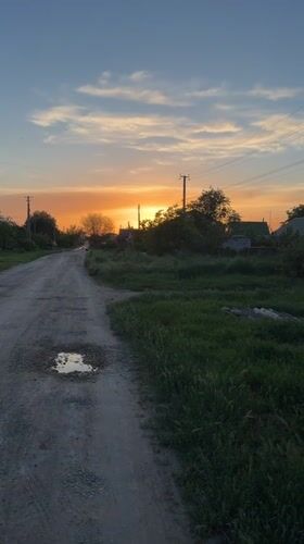 Rural sunset scene documented on dirt road in Leningradskaya