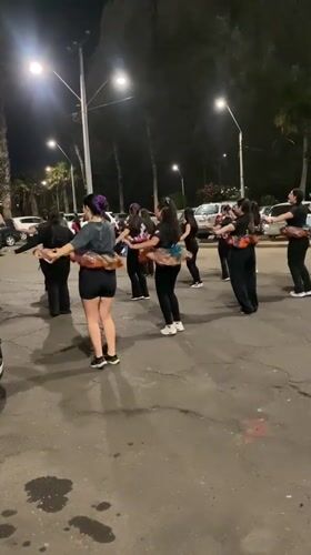 Dance group performs synchronized routine in Arica parking lot