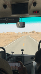 Bus travels desert road near Dunhuang City, China